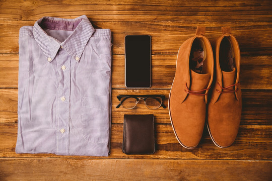 钱包和智能手机旁边的衬衫鞋
