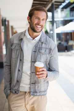 微笑的男人拿着一杯咖啡