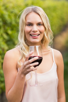 微笑的女人拿着一杯红酒