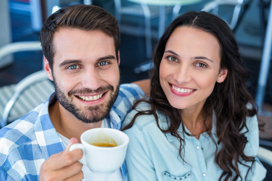 微笑的一对夫妇在咖啡馆里喝咖啡