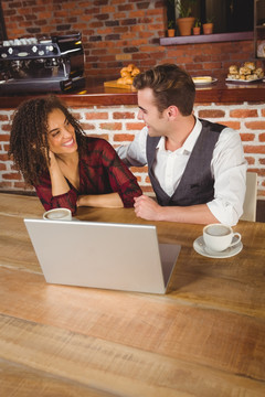 年轻夫妇在咖啡馆里用笔记本电脑