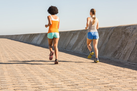 在长廊上跑步的两个年轻女人