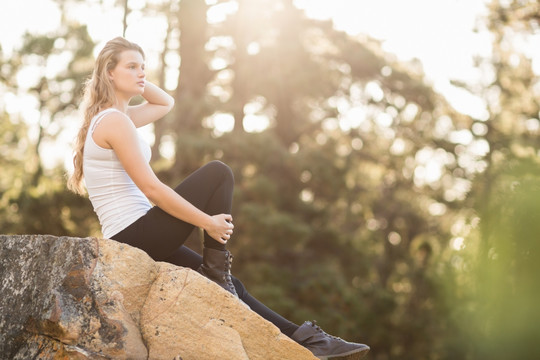 坐在岩石上的年轻女人
