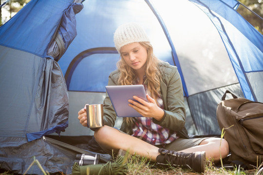 坐在帐篷里使用平板电脑的女人