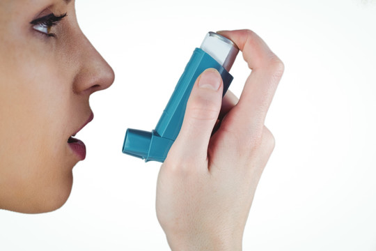 女人使用哮喘吸入器