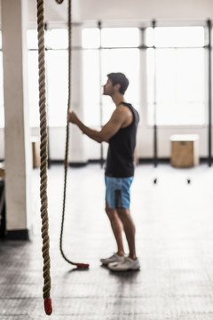在健身房里看着绳索的男人