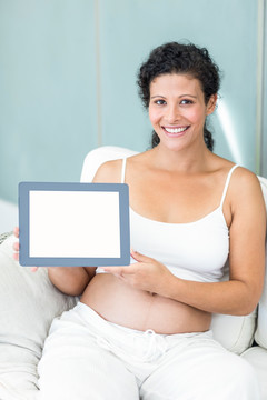 微笑着拿着平板电脑的孕妇
