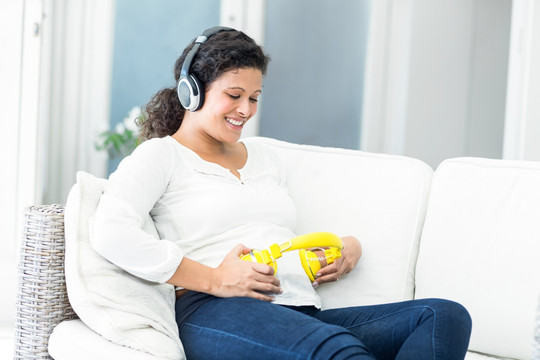 戴着耳机听音乐的孕妇 