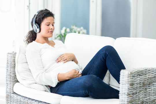 戴着耳机听音乐的孕妇 