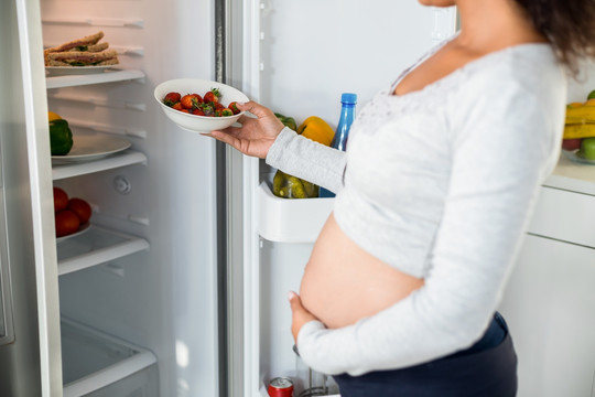 打开冰箱的孕妇