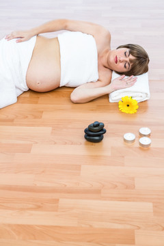 躺在水疗中心地板上休息的孕妇