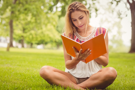 坐在公园草地上看书的女人