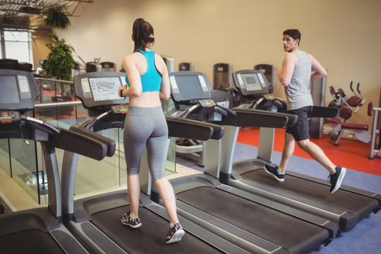 在健身房里使用跑步机的女人