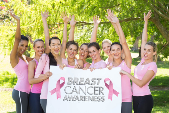 在公园举起手臂的乳腺癌志愿者们