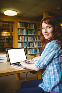 在图书馆使用笔记本电脑的女人