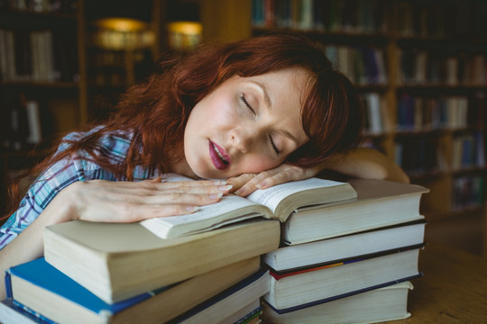 趴在书上睡着的女大学生