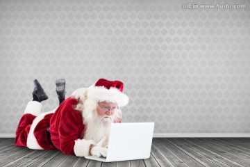 趴在地上使用电脑的圣诞老人