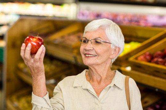 在超市里拿着两个苹果的老太太