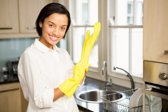 戴着橡胶手套的女人在厨房里