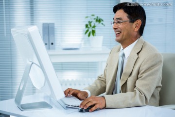 微笑着看着电脑的商务男人