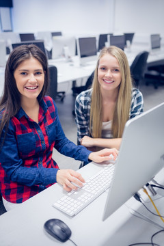 微笑的学生在大学里使用电脑