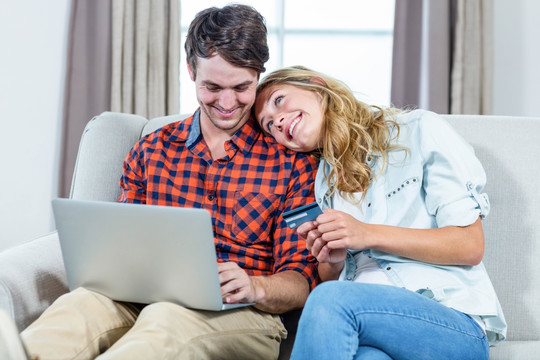 微笑着在笔记本电脑上网购的夫妇