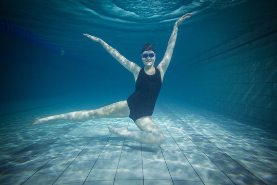 在游泳池里伸展身体的女运动员