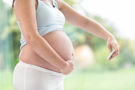 孕妇拿着手机拍腹部