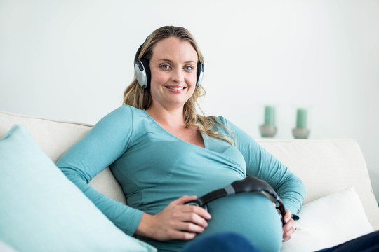 把耳机戴在肚子上给宝宝听的孕妇
