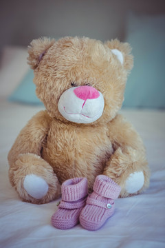 床上的泰迪熊和婴儿袜