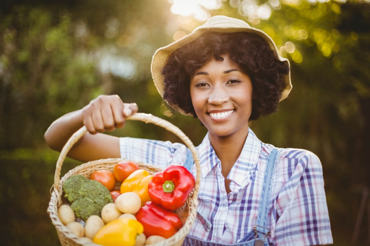 微笑的女人拿着一篮子蔬菜