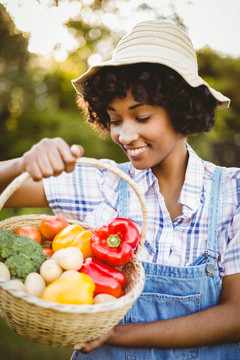 微笑的女人看着一篮子蔬菜