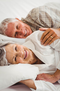 微笑的老夫妇躺在床上