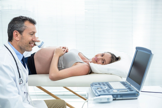 躺在病床上接受超声检查的孕妇