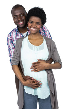 男人微笑着拥抱怀孕的妻子