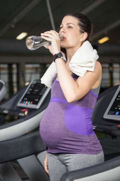 在健身房里喝水的女人
