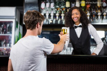 酒吧女招待服务员递一杯酒给顾客