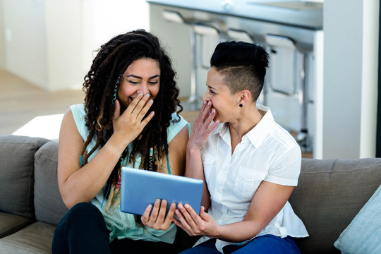开心的两个女人看着平板电脑