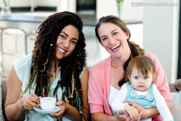 微笑的两闺蜜和一个婴儿在客厅里