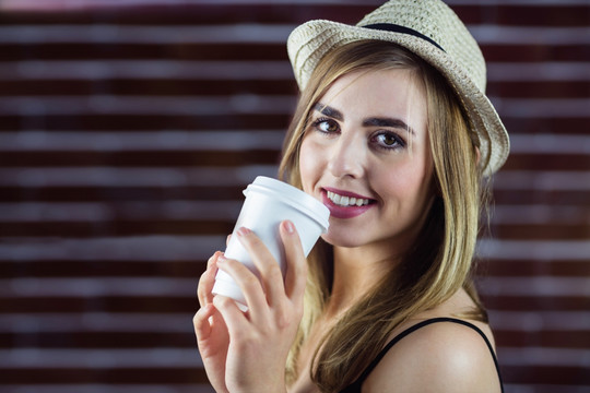 微笑的女人拿着一杯咖啡