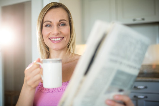 边喝咖啡边看报纸的女人