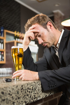 疲倦的男人在酒吧里喝威士忌