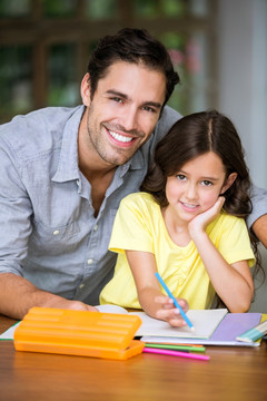 微笑的父亲在教女儿做作业
