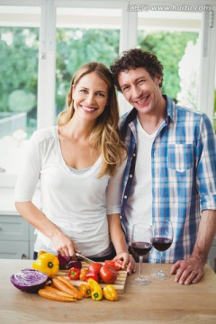 微笑的一对夫妇在厨房里切蔬菜