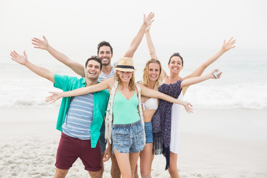 一群快乐的朋友站在沙滩上