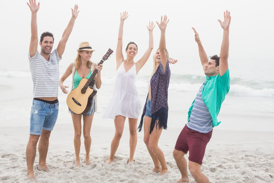 在沙滩上弹吉他给朋友听的女人