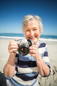 在海边拍照的老太太