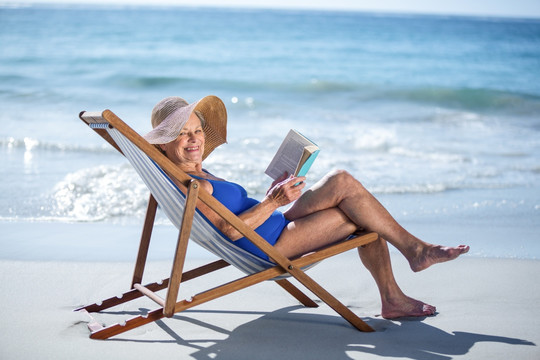 坐在沙滩椅上看书的老太太