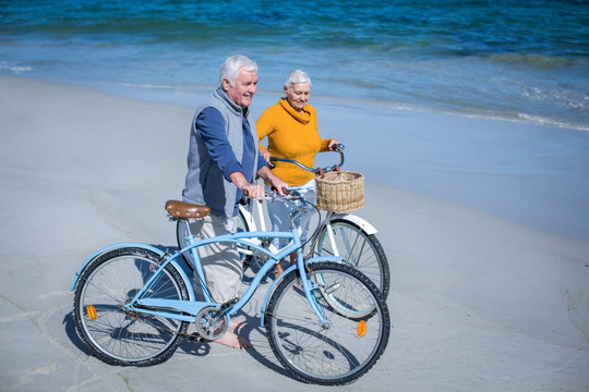 在沙滩上骑自行车的老夫妇