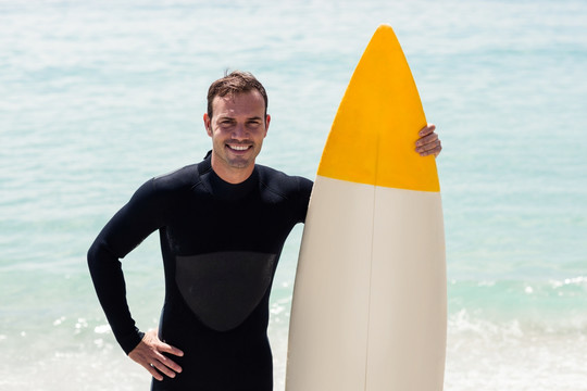 微笑的男人拿着冲浪板